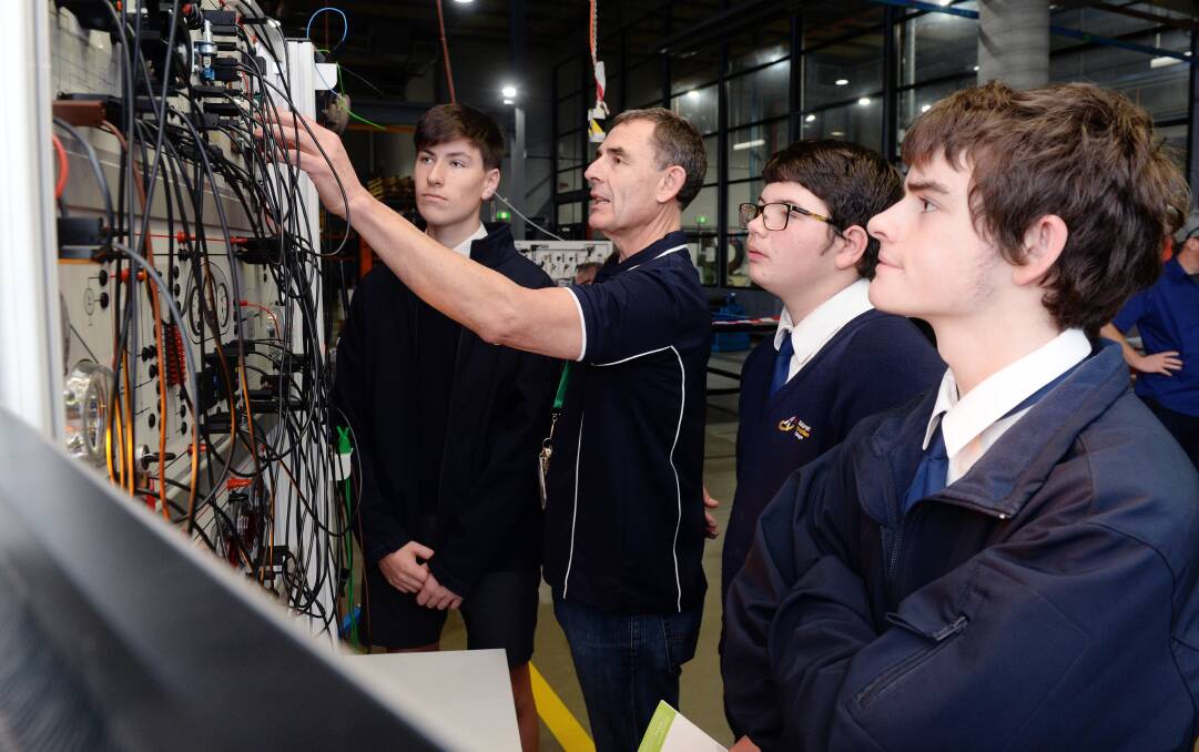 DISCOVERY: Year 10 students Ethan, James and Ryan gets some hands-on wiring experience with Federation TAFE automotive teacher John Rhook. Picture: Kate Healy
