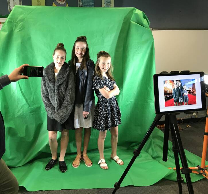 PAPPARAZZI: Charlotte, Tilly and Bonnie from CBT Productions are snapped on multiple cameras in front of the green screen at Pleasant Street Primary School's film festival. Picture: Michelle Smith