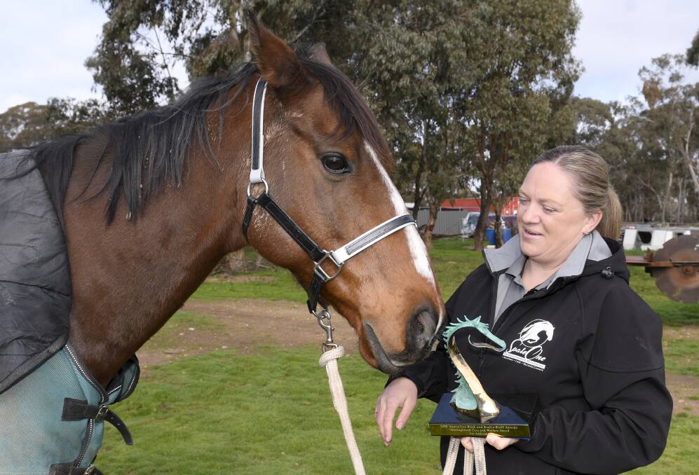 PREPARING FOR A NEW FUTURE: Liz Andriske with one of the eight ex-racehorses she currently has on her property at Adelaide Lead and the prestigious Godolphin Award for care and welfare after racing which she received this month. Picture: Lachlan Bence