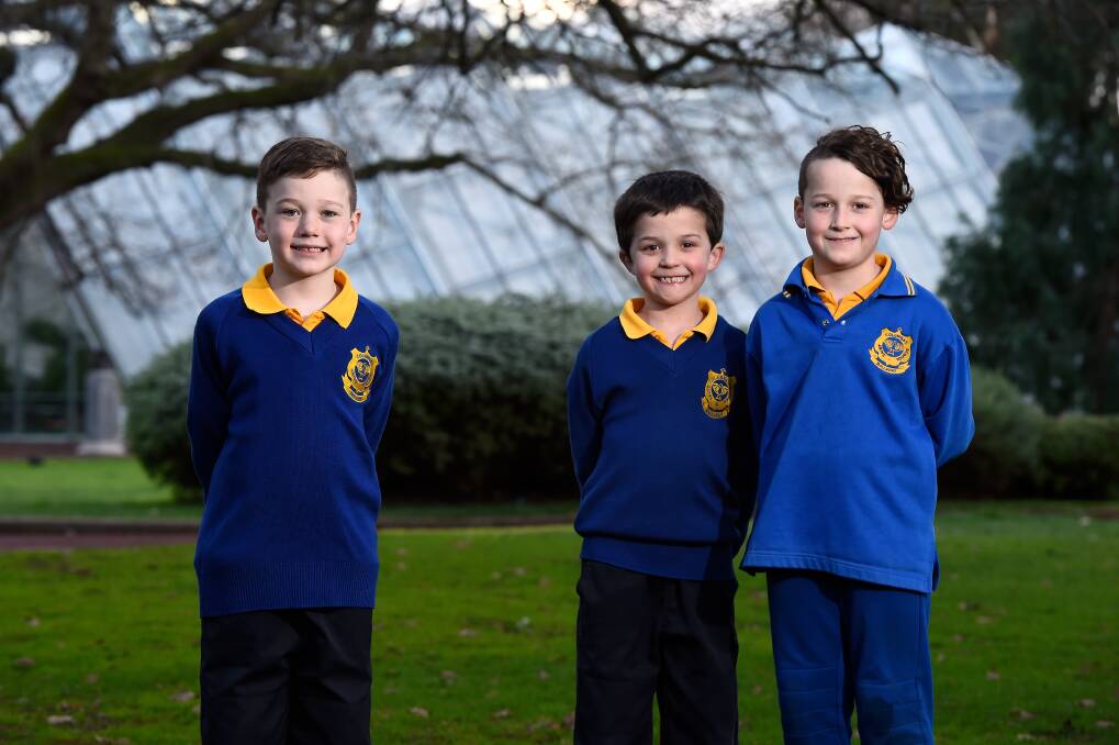 CLASS TIME: Cousins and St Columba's School students Oscar, Ethan and Darcy Biggin were happy to get back to school for the first day of term three. Picture: Adam Trafford