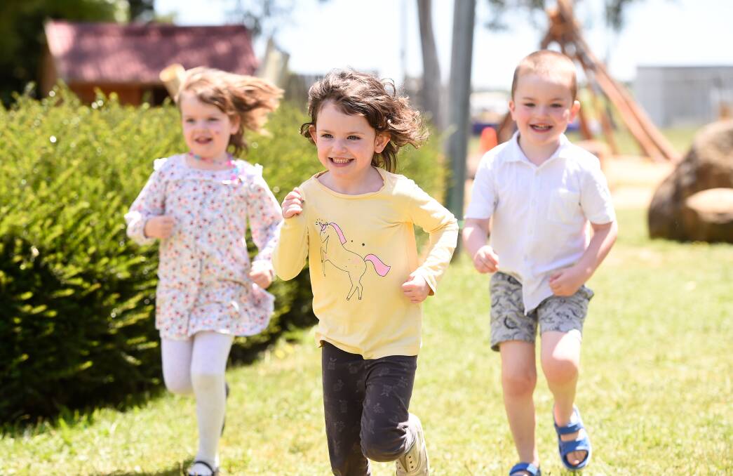 Triplets Amelia, Molly and Jacob take a run in the new playground at Delacombe Community Kindergarten. Picture: Adam Trafford