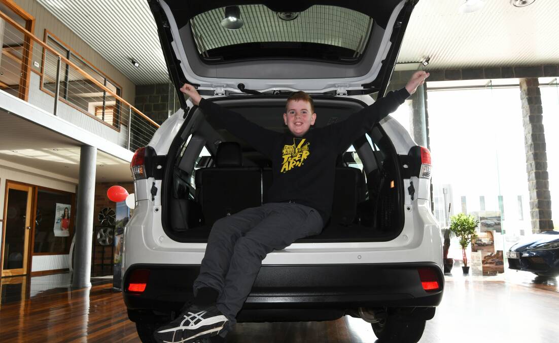 NEW WHEELS: Blake Dridan explores the Toyota Kluger which Ballarat Toyota donated to his family for a year after thieves stole and torched their ute in July. Picture: Lachlan Bence