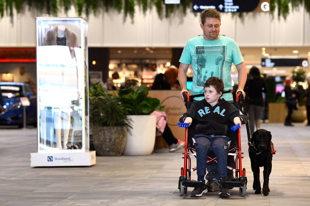 SHOPPING: Kayle and his dad Allan Griffin navigate the shoppers of Stockland Wendouree with Luna by their side. Picture: Adam Trafford