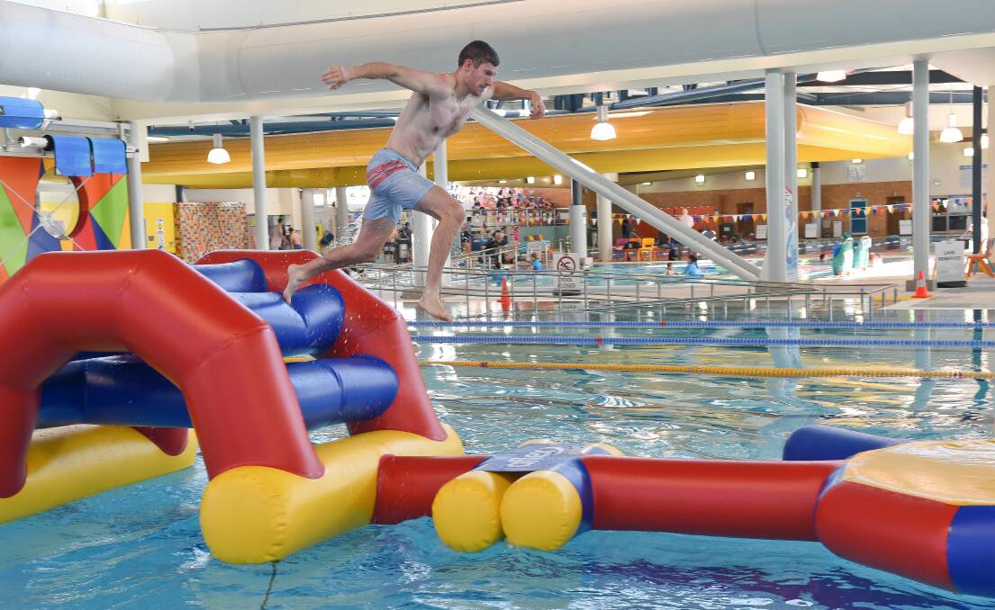 AQUATIC FUN: BALC lifeguard team leader Chris Delahunty takes a leap as he tackles the new 34m long inflatable obstacle course.