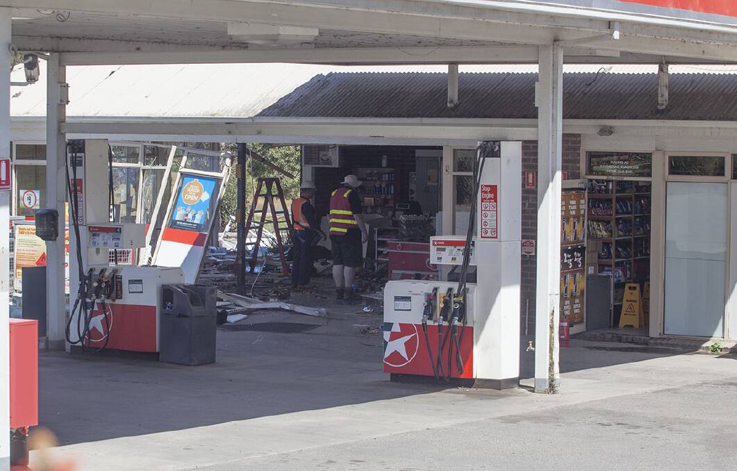 DESTRUCTION: Workers survey the damage left in the wake of a bobcat ram raid at Smythesdale's Caltex service station. Picture: Mark Smith