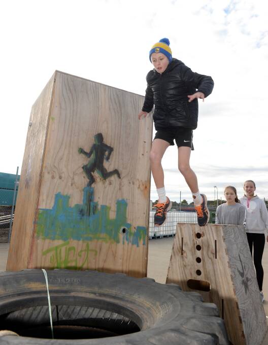 BIG LANDING: Jake Adrams, 9, learns the art of a safe jump as he leaps on to tyres during a school holiday parkour class at Ballarat Gymsports. Picture: Kate Healy