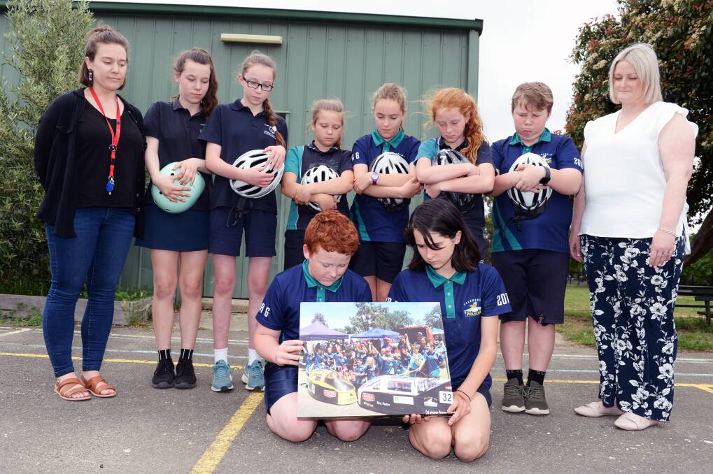 GUTTED: Jonah and Tia hold a picture of the carts at a previous event with school EB coordinator Prue Morrison, team members Molly, Reese, Tayah, Alana, Jovie, Brady and principal Brea Terris looking on. Picture: Kate Healy