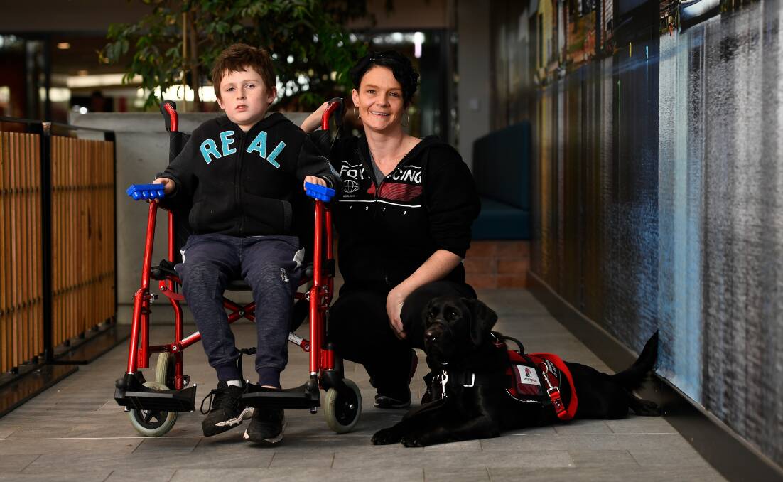 LEARNING: Kayle Griffin, 12, mum Christy Cook and his assistance dog Luna during a training outing at Stockland Wendouree. Picture: Adam Trafford