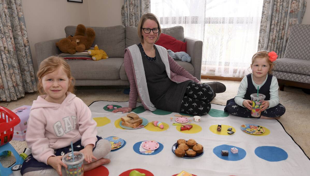 PICNIC: Kylie Watson with twins Lily and Matilda, 6, with their loungeroom picnic that was this week's activity set as part of Mount Pleasant Primary School's fun Fridays. Picture: Lachlan Bence