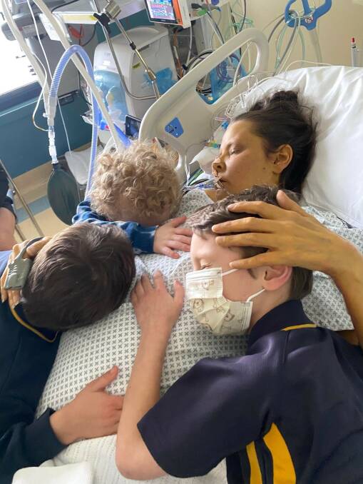 Ezra, Azayah and Taylar give mum Kellie a hug in the intensive care unit. Picture supplied