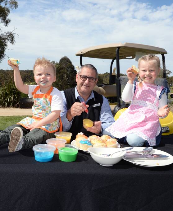 CUPCAKE JOY: Xavier Riordan, 2, RACV Goldfields Resort's Ian Lane, and Ava Riordan, 3, get in some practice before next month's SpringFest where cupcake decorating will be one of the children's activities. Picture: Kate Healy