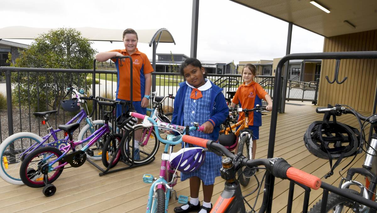 PARKING: Siena Catholic Primary pupils Will, Isabel and Maddy in the school's 'bike park' on the deck. Picture: Lachlan Bence