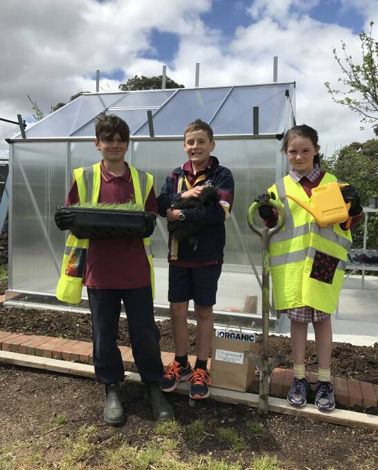 GREEN THUMBS: Delacombe Primary pupils Jaxon, 9, Toby, 12, and Isabelle, 10, welcome the new greenhouse for their kitchen garden. Picture: Michelle Smith