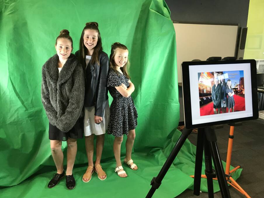 POSE: Charlotte, Tilly and Bonnie from CBT Productions strike a pose for their green screen red carpet picture at Pleasant Street Primary School's film festival. Picture: Michelle Smith