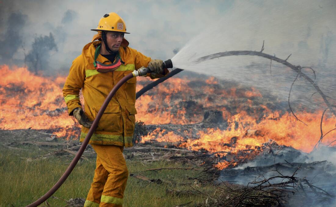 CFA crews hose down a grass fire at Snake Valley in 2014.