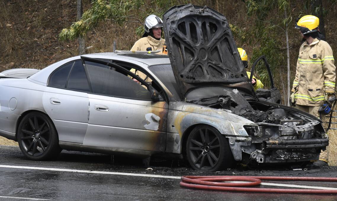CHARRED: Firefighters assess a car which caught fire on the Western Highway at Nerrina just after 12.15pm. Picture: Lachlan Bence