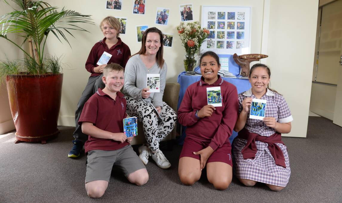 PLAN: Jet (Grade 5), Ethan (Grade 5), wellbeing leader Emily Clarke, Sarasa (Grade 5) and Sharni (Grade 6) with their copies of the St Alipius Parish School Reconciliation Action Plan. Picture: Kate Healy