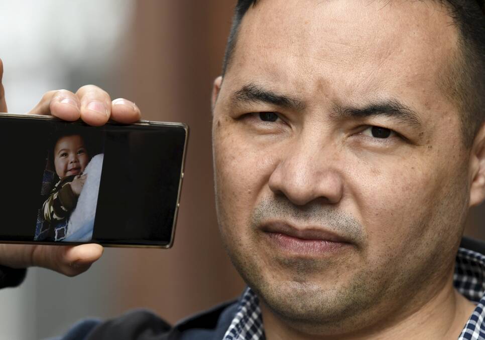CONCERN: Nadir Heidari with a picture of his son Navid, 11 months, who he has not met and who is in hiding with his mother in Afghanistan following the Taliban uprising. Picture: Lachlan Bence