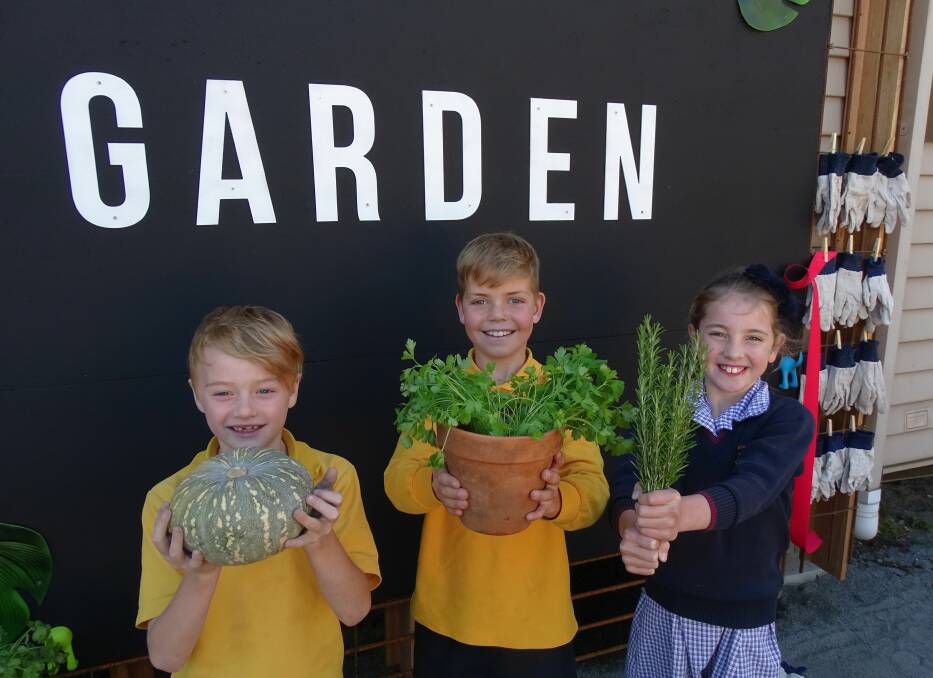 GROWING: St Aloysius Primary School pupils Cooper, Jacob and Charlotte show off pumpkin, parsley and rosemary from their newly-opened kitchen garden, which year three and four classes will tend to and learn from.      