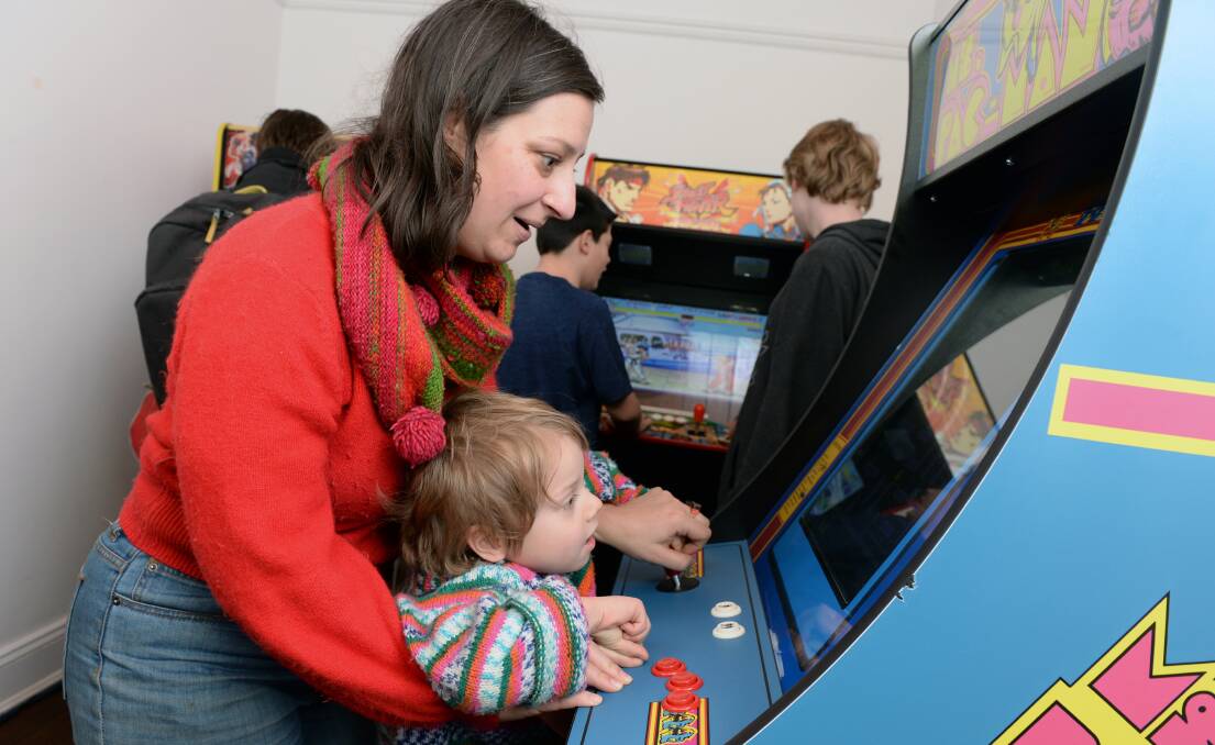 PLAYTIME: Natasha Ludowyk and Hugo Thomas, 4, check out some retro gaming fun during the Ballarat Winter Festival's Winteractive Arcade at the Mining Exchange.