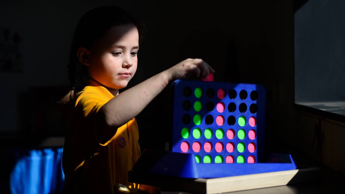 CONCENTRATION: Ella, 7, creates patterns with Connect Four in Alfredton Primary School's sensory room. Picture: Adam Trafford