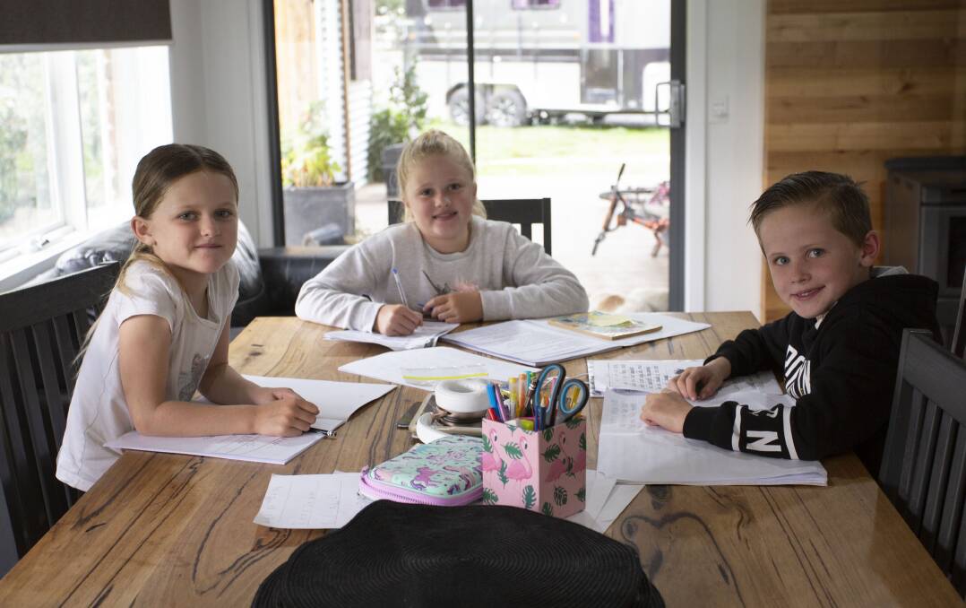 TOGETHER: Ivy, 6, Scarlett, 10, and Harry, 8, complete their school work at the kitchen table. Picture: Amy Smith