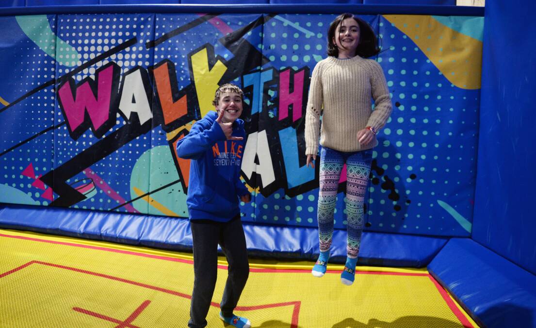 BOUNCE: Patterson Bridges, 14, and Jasmine Nanscawen, 14, jump off some energy at Xtreme Bounce as part of the Pinarc school holiday program. Picture: Kate Healy 