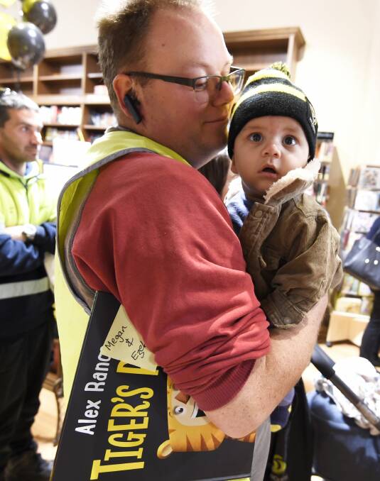 TINY FAN: Ben McKay made sure to grab a copy of Tiger's Roar and have it signed by its footballer-turned-author Alex Rance for six-month-old Ezekial. Picture: Lachlan Bence