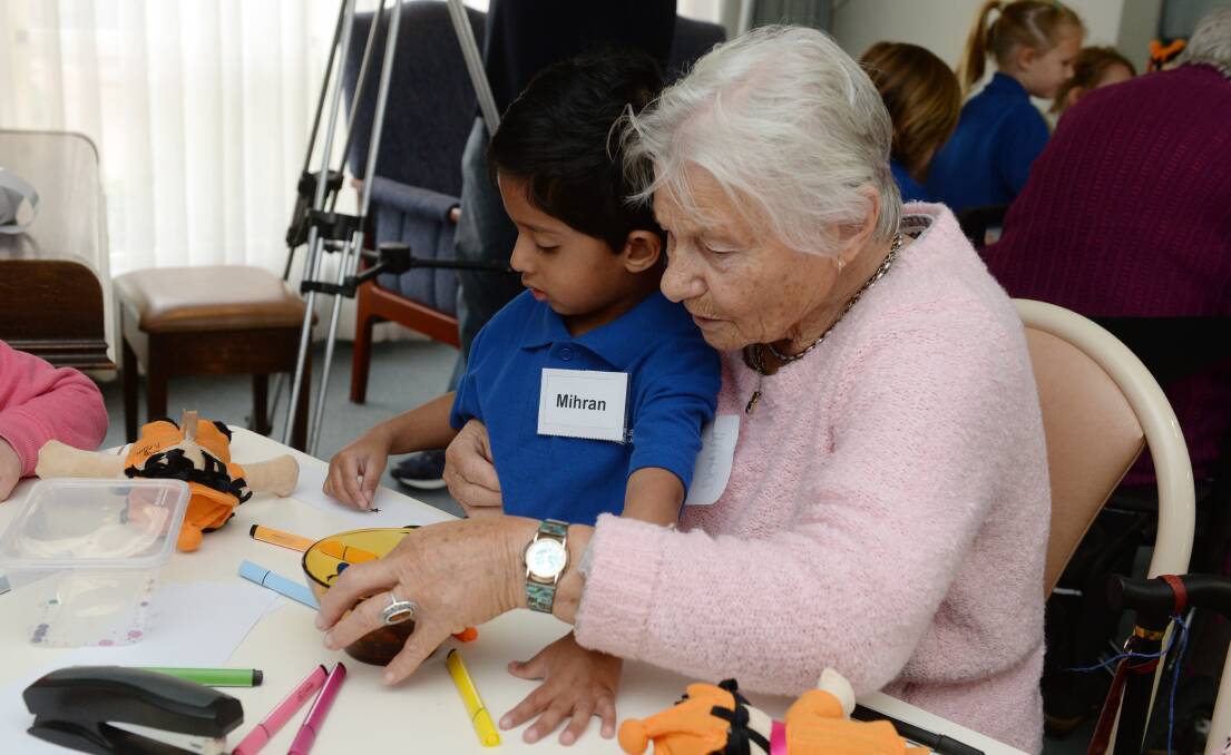 ACTIVITY: Mihran and Maria bond over a craft activity during a session to build relationships between the youngest and oldest members of the community. Picture: Kate Healy