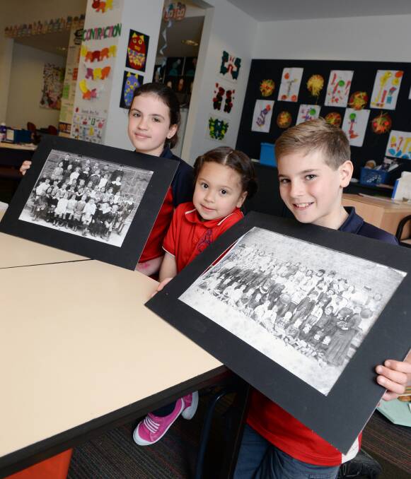 HISTORY: Year six pupils Bonnie and Lincoln show foundation student Matilda the Linton Primary School photos from generations ago. Picture: Kate Healy 