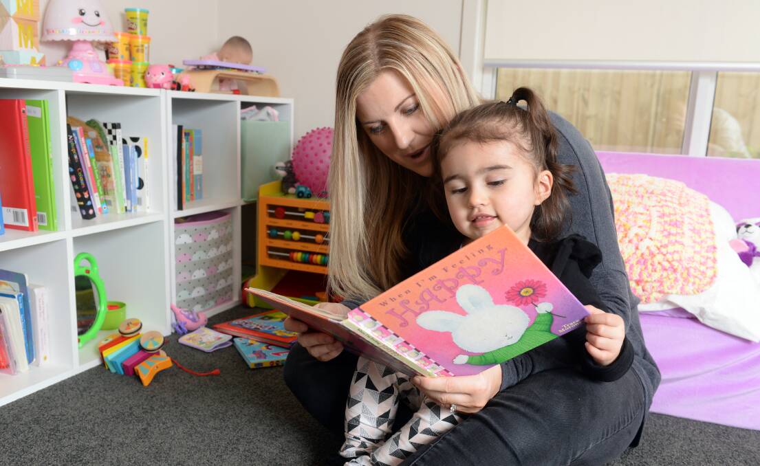 CUDDLES: Emma Banks, 2, and mum Dee Honeychurch include physical and speech therapy in their everyday activities to help Emma overcome the effects of a stroke she suffered before she was born. Picture: Kate Healy