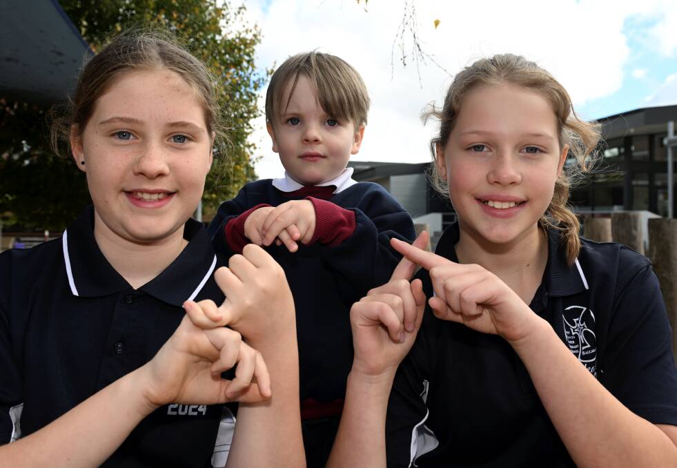 All pupils at St Francis Xavier Primary School including grade six students Matilda and Emma, and foundation student Jasper, are learning Auslan as a second language.Picture by Lachlan Bence