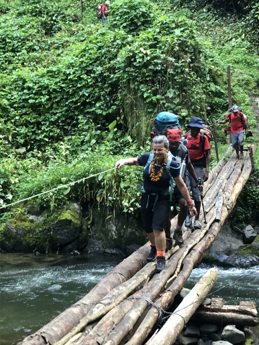 CROSSING: Porters escort Liz Crothers over one of the many river crossings on the gruelling Kokoda Track.