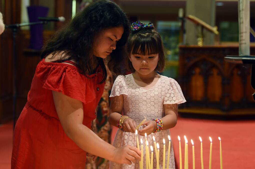 REMEMBERING: Genie and Arianna, 6, light a candle during the interfaith community and harmony week vigil at the Ballarat Anglican Cathedral. Picture: Kate Healy