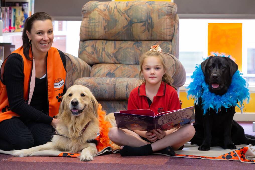 ALL EARS: Buninyong Primary School pupil Millie reads to story dogs Honey and Gertie and Story Dogs Ballarat coordinator Jacqui MacMillan. Picture: supplied
