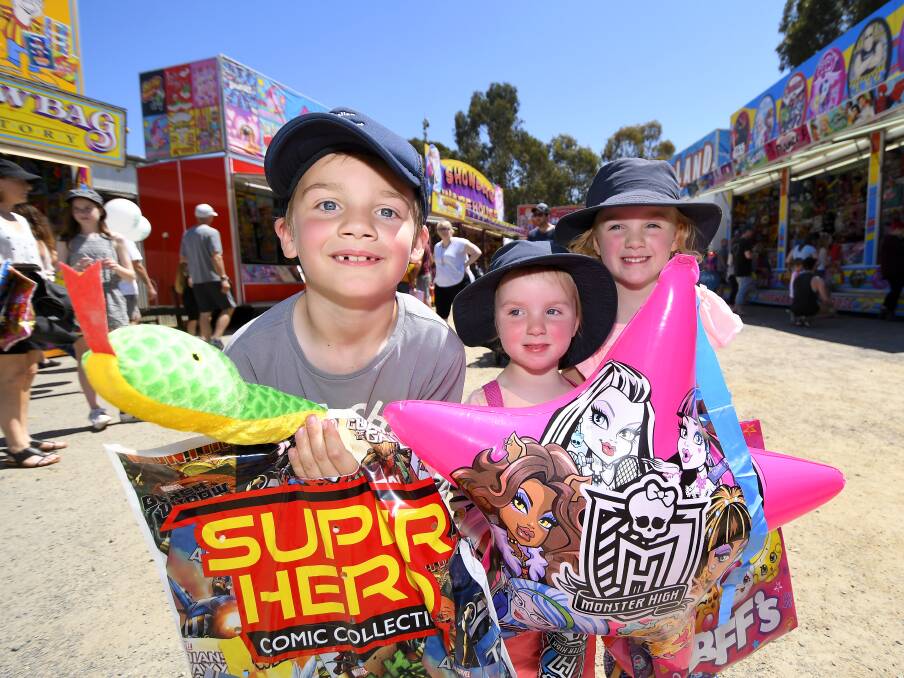 SHOWBAG HAUL: Archie, 7, Eleanor, 2, and Audrey, 5, from Navigators, show off their prized showbag purchases on the final day of the Ballarat Show. 