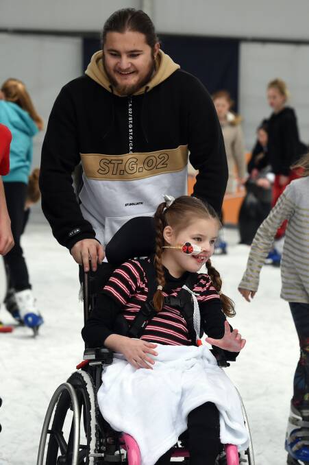 ALL SMILES: Blake Corbell gives his little sister Sienna a push around the ice after finding his own feet on the ice. Picture: Kate Healy