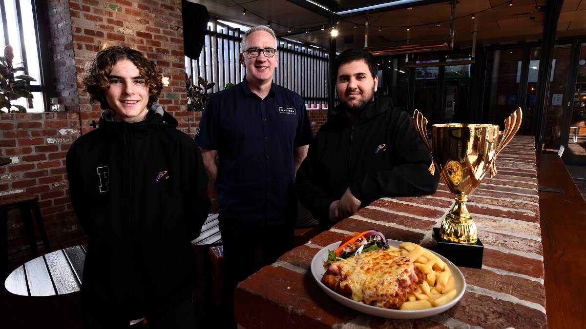 Phoenix P-12 Community College students Lincoln Willems (left) and Jalal Hawli with Western Hotel owner and manager Dan Cronin and the inaugural Parma Cup, which at least six local eateries will vie for selling parmas to raise money for FECRI during August. Picture by Adam Trafford