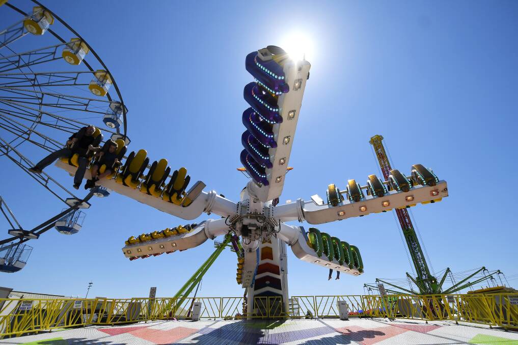 ADRENALINE: Thrillseekers are flung upside down as they take on one of the stomach-churning rides under the bright sunshine as the Ballarat Show draws to a close.