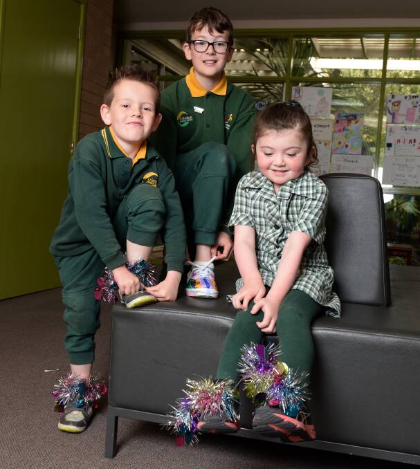 FANCY BOOTS: Alfredton Primary School pupils Cohen, Harley and Amelia get in to the spirit of VicHealth's Walk to School month with their brightly decorated walking shoes. Picture: Kate Healy