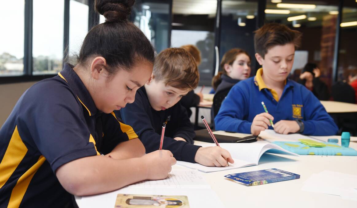 WRITING: Canadian Lead pupils Atelaite and Zyron and Woady Yaloak pupil Elliot work on their writing skills in the Ballarat Young Authors Program. Picture: Kate Healy