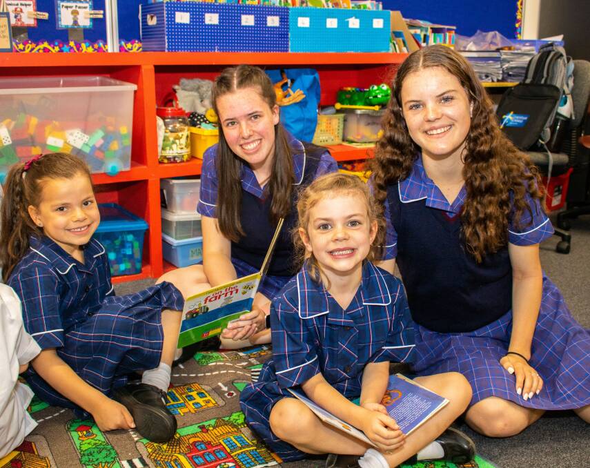 STORY TIME: Ballarat Christian College school captain Esther and vice captain Brianna help introduce new prep students Liliana and Zoe to the classroom on their first day of school. 