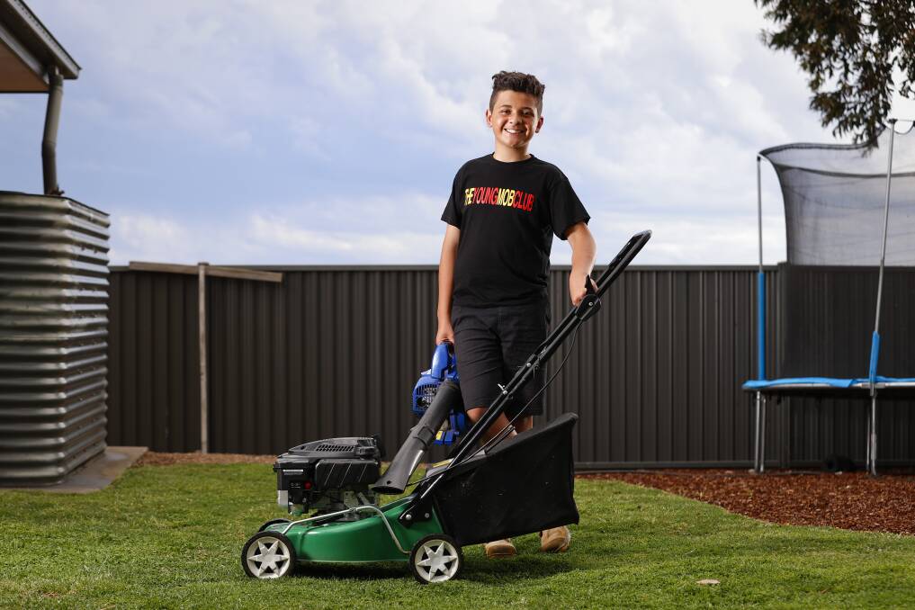WORKING MAN: Ryder Tucker with his lawnmowing tools of the trade wears a t-shirt from his The Young Mob Club business. Picture: Luke Hemer