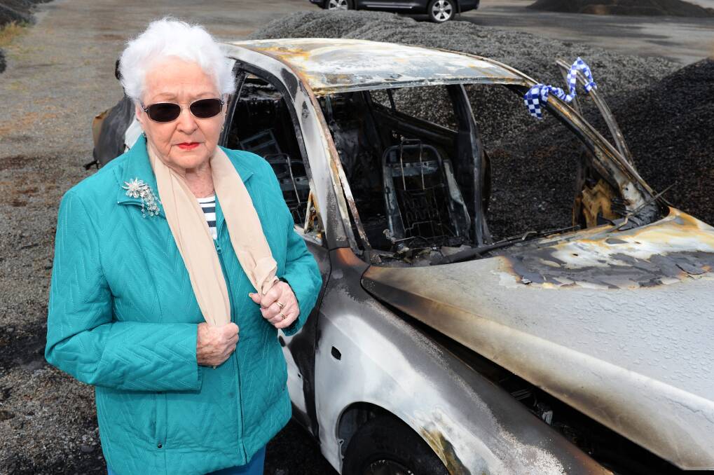ANGRY: Nell Hanrahan with her burnt out car. Picture: Kate Healy