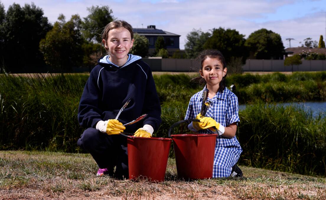 CLEANING: Ruby and Alyssa get ready for Lumen Christi Catholic Primary School's Clean Up Australia Day rubbish collection this week. Picture: Adam Trafford