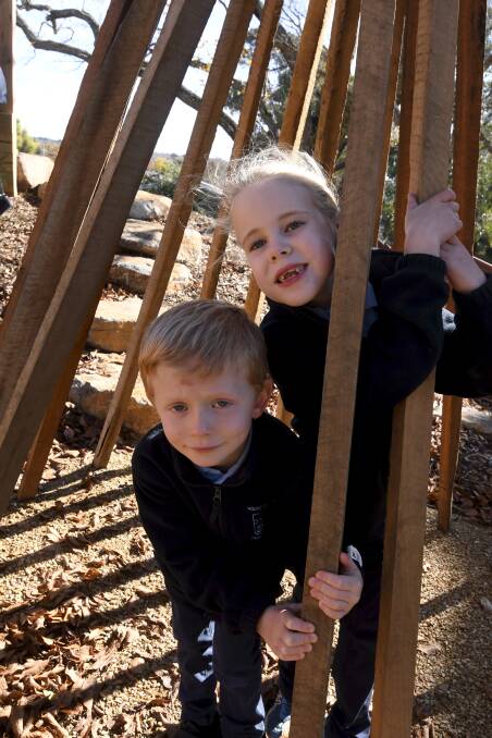 VILLAGE: Kaden and Zahara check out the village of wooden teepees, which was near the top of the list of items that pupils chose for their new playground. Picture: Lachlan Bence