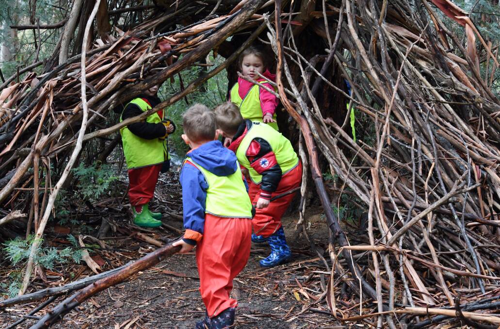 BUILDERS: The children have cooperated to build a series of cubby houses using sticks and branches.