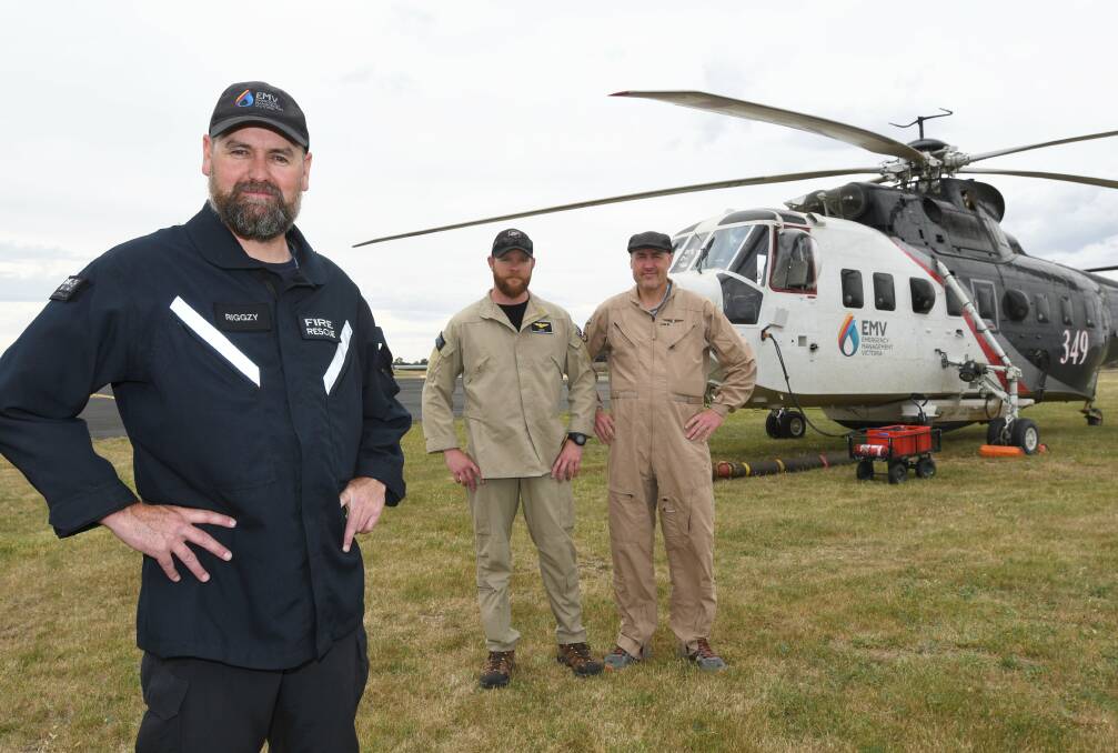 READY: Night water bombing project leader Wayne Rigg and pilots Dave Thiessen and Jim Tarnowski with the Coulson Aviation S-61 ready to fight fires at night. Picture: Lachlan Bence