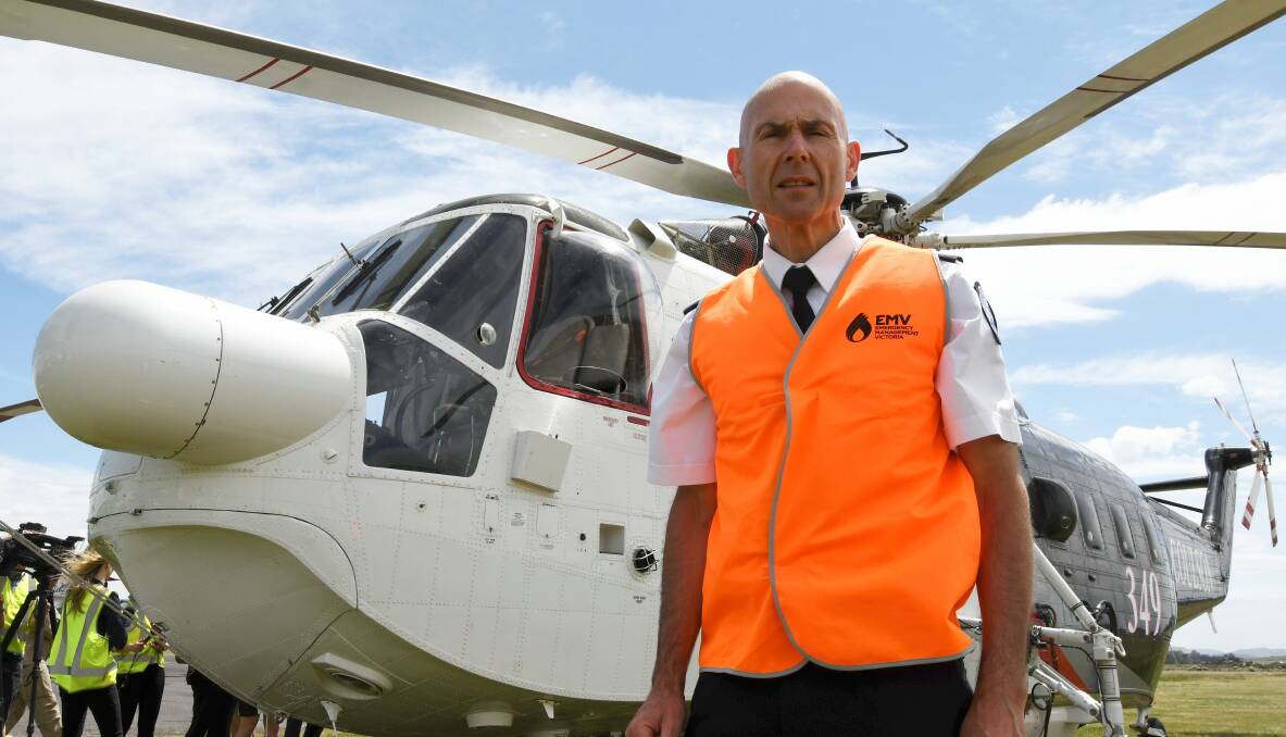 READY: Emergency Services commissioner Andrew Crisp at Ballarat airfield with one of the two firebombing helicopters approved to fight fires after dark. Picture: Lachlan Bence