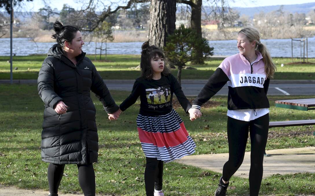 STEPS FOR SKYE: Skye Robson (centre) with carers Bree Pellow (left) and Teghan Henderson take a walk. Picture: Lachlan Bence